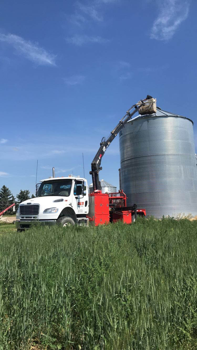 A truck stands next to a large silo, highlighting the connection between agriculture and logistics.
