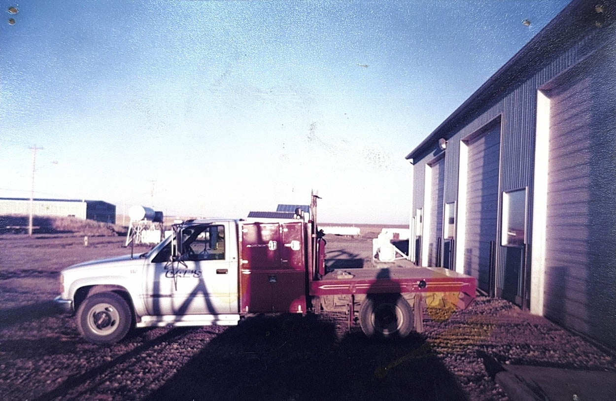 A old image of a white truck is parked in front of a building, showcasing its clean exterior